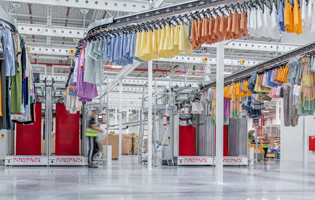 Garment handling conveyor system from a side perspective, optimising storage space and workflow in clothing warehouses.