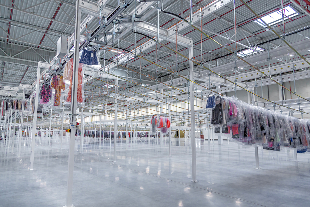 Detail of garment conveyor system with automated switches directing garments to a loading dock area.