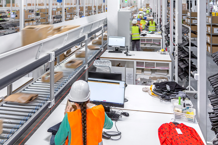 Garment inspection station in an e-commerce logistic hub